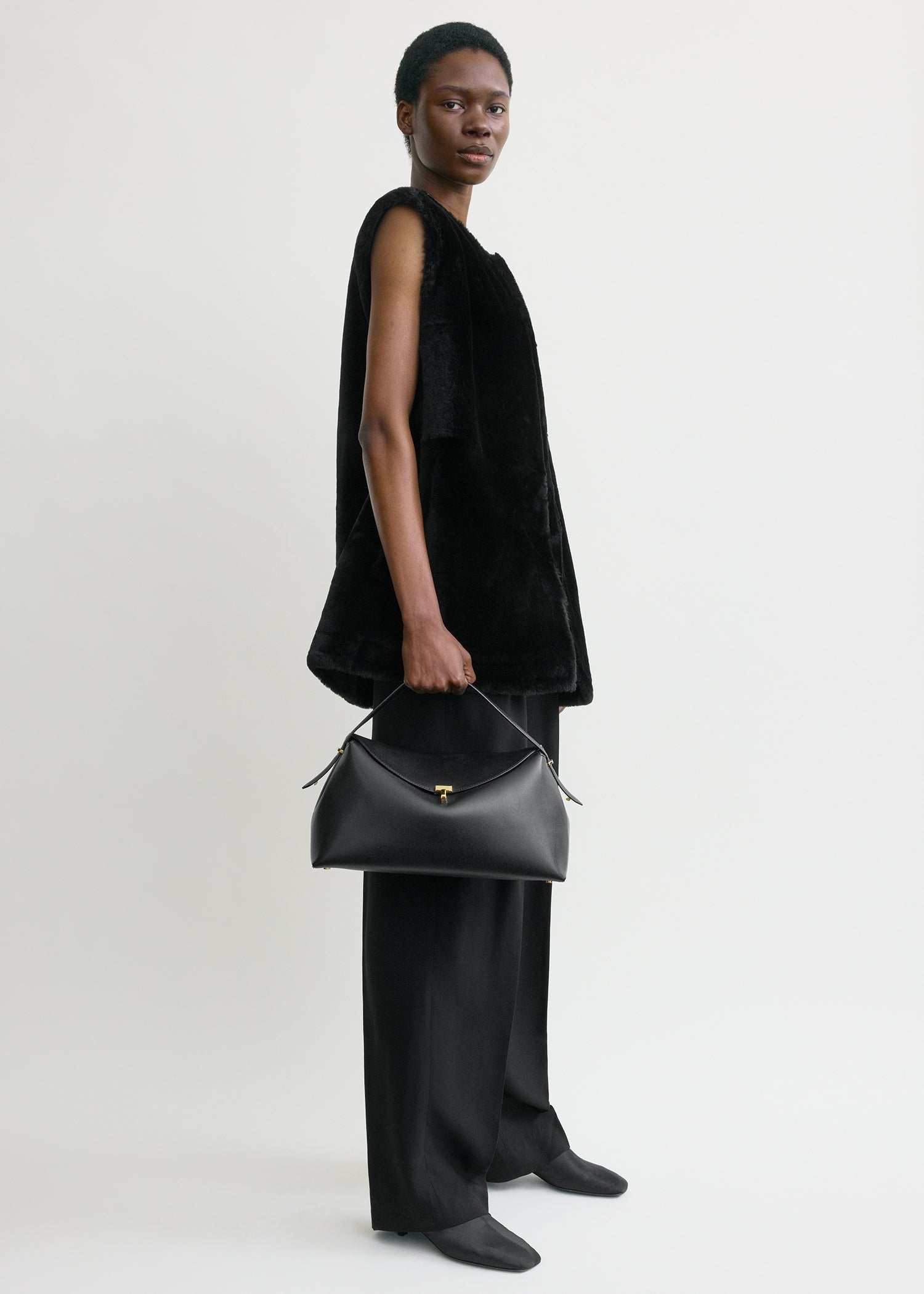 Toteme T-Lock Leather Top Handle in Black - side view